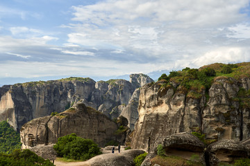 Amazing Meteora Monastery in Greece. Fantastic view at mountains and green forest against epic blue sky with clouds. UNESCO