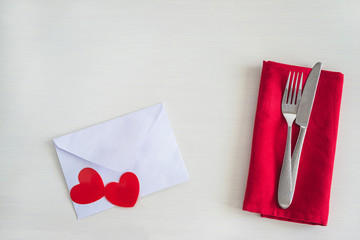 Wall Mural - Romantic table setting. Beautiful cutlery on red napkin, two red hearts on white envelope