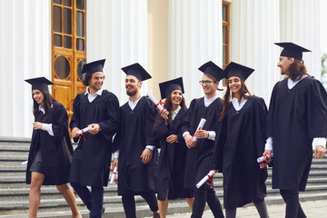 Wall Mural - Group of students graduates go against the university college.