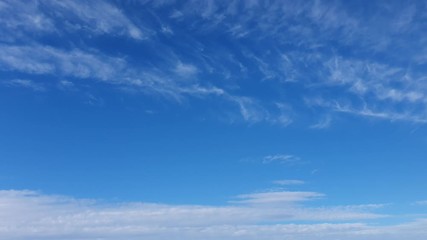 white clouds disappear in the hot sun on blue sky. time-lapse motion clouds, blue sky background and