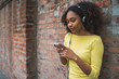© Mego-studio - Afro-American woman with mobile phone and headphones