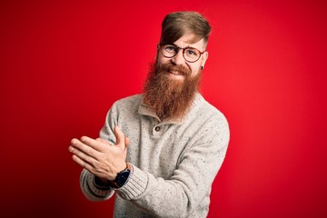 Sticker - Handsome Irish redhead man with beard wearing casual sweater and glasses over red background clapping and applauding happy and joyful, smiling proud hands together