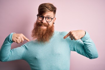 Poster - Handsome Irish redhead man with beard wearing glasses over pink isolated background looking confident with smile on face, pointing oneself with fingers proud and happy.