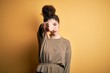 © Krakenimages.com - Young beautiful brunette woman with curly hair and piercing wearing casual dress looking unhappy and angry showing rejection and negative with thumbs down gesture. Bad expression.