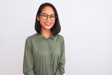 Wall Mural - Young chinese woman wearing green shirt and glasses over isolated white background with a happy and cool smile on face. Lucky person.
