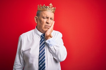 Sticker - Senior handsome businessman wearing king crown standing over isolated red background thinking looking tired and bored with depression problems with crossed arms.