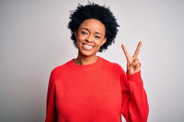 Young beautiful African American afro woman with curly hair wearing red casual sweater showing and pointing up with fingers number two while smiling confident and happy.