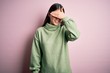 © Krakenimages.com - Young beautiful asian woman wearing green winter sweater over pink solated background smiling and laughing with hand on face covering eyes for surprise. Blind concept.