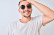 © Krakenimages.com - Young handsome man wearing sunglasses and casual t-shirt over isolated background stressed with hand on head, shocked with shame and surprise face, angry and frustrated. Fear and upset for mistake.