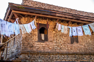 Wall Mural - Clothes hanging from a clothesline from a stone house