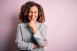 Middle age beautiful businesswoman wearing elegant jacket over isolated pink background looking confident at the camera smiling with crossed arms and hand raised on chin. Thinking positive.