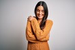 © Krakenimages.com - Young beautiful brunette woman wearing casual sweater over isolated white background Hugging oneself happy and positive, smiling confident. Self love and self care