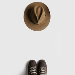 Wall Mural - vintage hiking boots and hat on white background isolated. minimalist backpacking travel concept fla