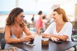 © Krakenimages.com - Beautiful mother and daugther sitting at terrace of a restaurant speaking and smiling