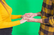 Cropped shot of hands in hands together over green background.