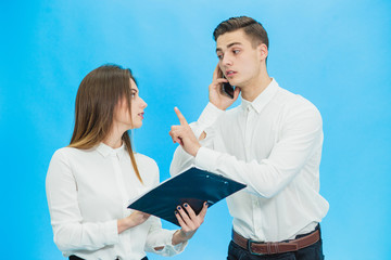 Young secretary distracts boss to sign a document while he is talking on mobile phone.