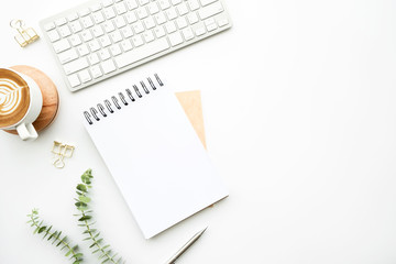 blank notebook is on top of white minimal office desk table with cup of latte coffee and supplies. t