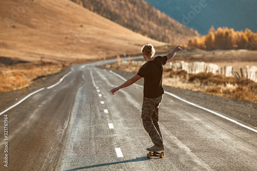 Cuadros en Lienzo Lonely skateboarder on longboard at mountain road