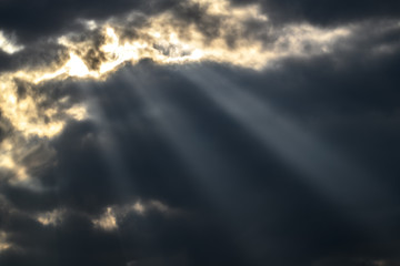 sunlight beam through grey clouds