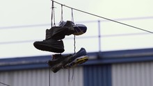 Close Up Of Shoes Tied At The Laces And Hanging From A Telephone Wire
