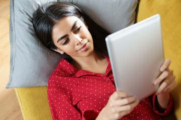 Wall Mural - Persian woman at home using digital tablet