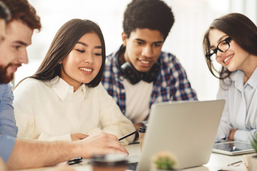 Wall Mural - Multiethnic college students checking test results on laptop