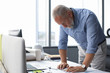 © ty - Good looking mature architect drawing something while working in the office.