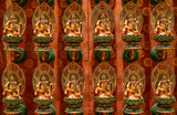 Fototapeta Desenie - Many small urns for the ashes of the dead in the shape of Buddha in a  Buddhist temple in Singapore