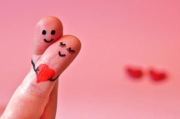 valentine's day, Happy couple in love. 2 fingers holding red heart while smiling face with hearts bokeh background. happy couple in love with painted smiley and hugging. copy space