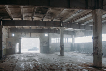 Inside old ruined abandoned industrial building in the fog