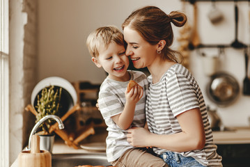 Wall Mural - preparation of family breakfast. mother and child son cut bread  and eat cookies with milk in morning