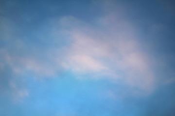 Wall Mural - dramatic blue sky with clouds backlit by the sun at dusk.