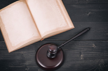 Wall Mural - Judge Gavel and law book on a black wooden background, law library concept.