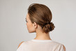 cute woman with beautiful elegant hair bun on gray background