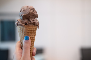 a girl holds ice cream cones chocolate.