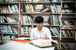 © Watcharin - Young teenager searching data from book,at library
