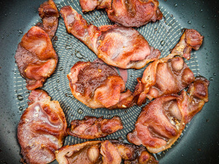 Greasy bacon cooking in a pan