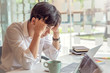 © amnaj - Asian businessman stressed with work in a cafe one.