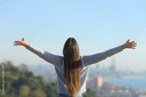 Fotomural Woman stretching arms looking at city background