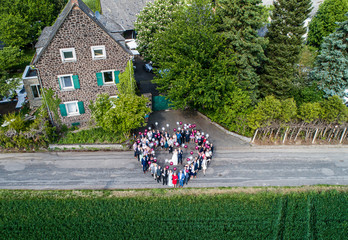 Wedding guests lined up in the shape of heart with bride and groom marriage people