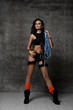 Young slim brunette beautiful woman in sportswear and rope protection equipment for industrial alpinism standing and looking up