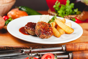 Wall Mural - Juicy delicious meat cutlets with potato wedges on white plate. Russian cuisine.