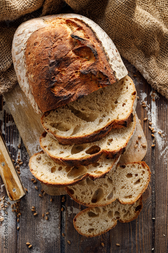 Fotomural Wheat and rye traditional sourdough bread cut into slices on a wooden board, top