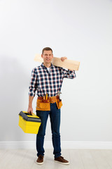 Sticker - Handsome carpenter with wooden planks near light wall