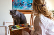 © encierro - Woman and her pet in art studio. Artist enjoying painting with her british shorthair cat