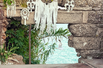 Wall Mural - Sea view through an opening of a stone wall