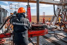 Offshore Oil Rig Worker Prepare Tool And Equipment For Perforation Oil And Gas Well At Wellhead Platform. Making Up A Drill Pipe Connection. A View For Drill Pipe Connection From Between The Stands.