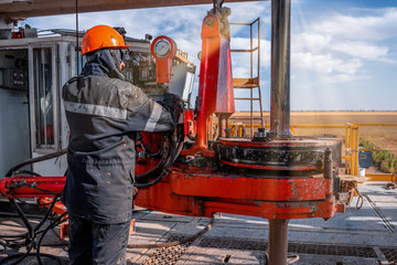 Wall Mural - Offshore oil rig worker prepare tool and equipment for perforation oil and gas well at wellhead platform. Making up a drill pipe connection. A view for drill pipe connection from between the stands.