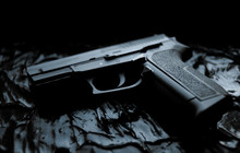 Gun Lies On A Dark Texture Background Close-up