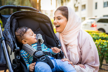 Wall Mural - Arabic mom and her little toddler playing outdoors